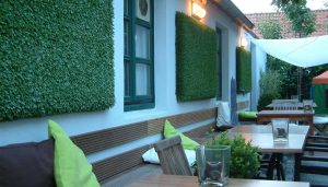 kunstgraspanelen aan de wand van restauranttuin