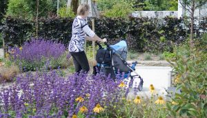 vrouw met kinderwagen in expositietuin
