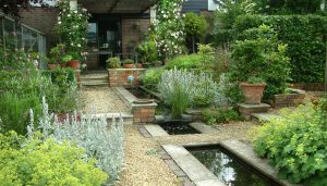 tuin met canal en weelderige beplanting